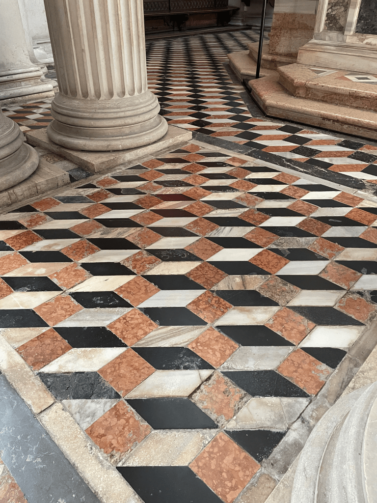 A tiled floor of white, red, and black stone
