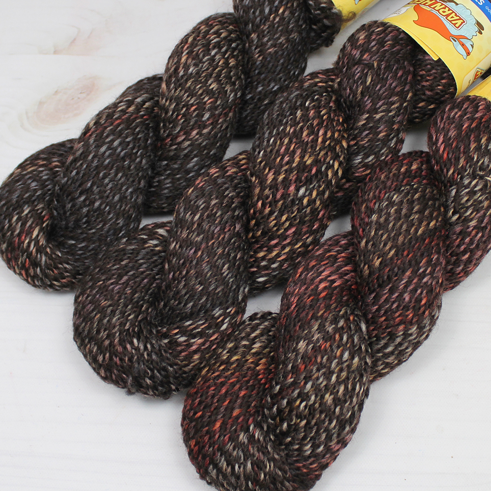 3 skeins of a multicolor, helix spun yarn with shades of black, gray, red, orange, and deep pink.